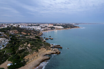 Obraz premium Aerial Drone View of the Blue Ocean and Waves Crashing Along the Beach in Albufeira Portugal