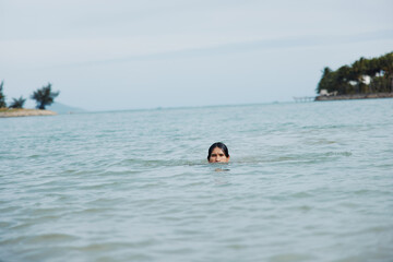 Swimming in Tropical Bliss: A Joyful Asian Man Embracing the Blue Waters of Summer