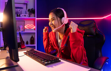 Host channel of smiling beautiful Asian girl streamer playing with raising fist up winning on...