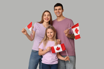 Happy family with flags of Canada on grey background