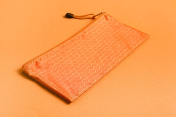Pencil case on orange background