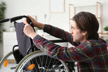 Young man repairing his wheelchair at home