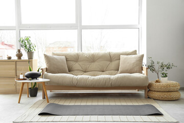 Interior of living room with sofa, yoga mat and glucophone
