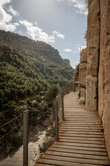 Fototapeta premium hiking trail caminito del rey, kings walkway, in Malaga Spain. narrow footpath leads through natural beauty mountain range cliff faces of gaitanes gorge. hisotric landmark popular tourist attraction