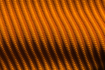 Closeup of orange corduroy cloth as patterned textured background