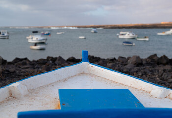 A boat is sitting in the water with a blue and white hull. The boat is in the middle of a large...