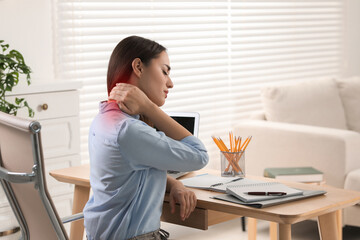 Woman suffering from neck pain at table