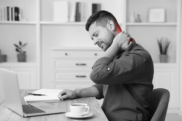 Man suffering from neck pain at table, black and white effect