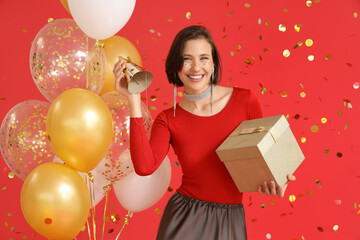 Beautiful woman with Birthday gift and balloons on red background