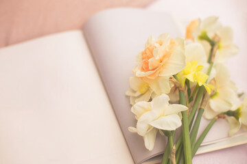 A bouquet of daffodils lies on an open book.