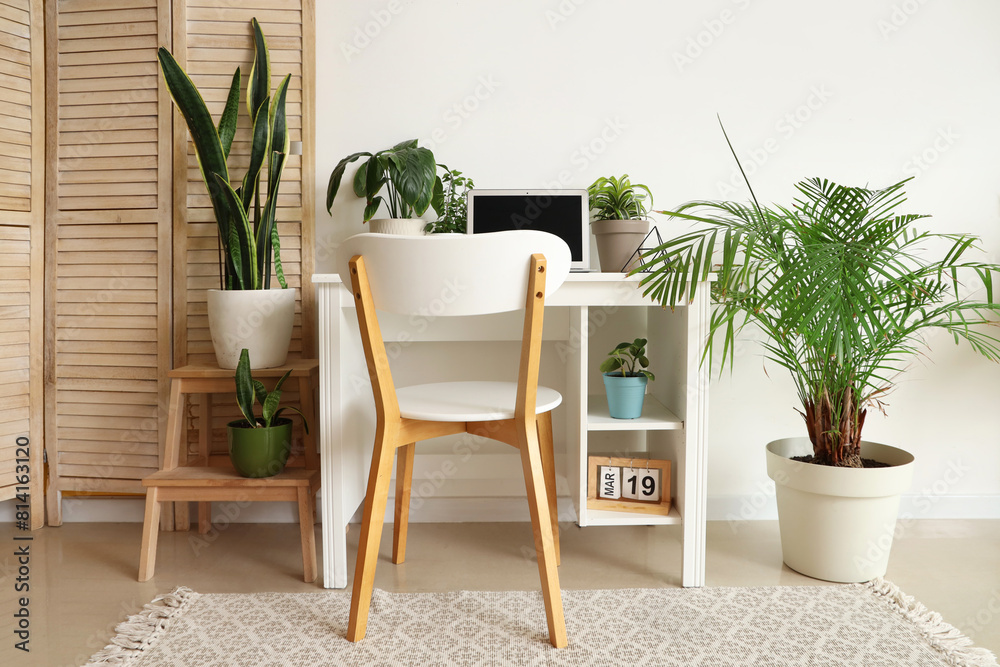 Sticker Workplace with laptop and green plants near light wall in office