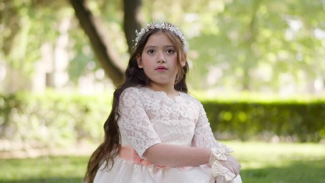 First Communion sweet girl wearing white dress changing expression suddenly.MOV