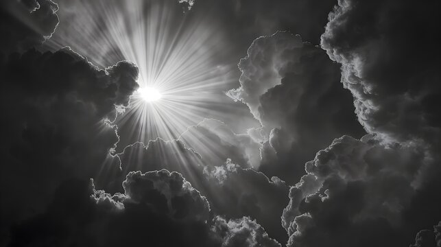 black and grey sun and rays bursting through clouds