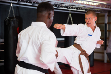 Two man in kimono fighting with each other in gym