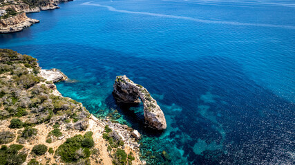 The coast of Cala D'or in South of Mallorca Spain in summer time on a sunny day with blue water and rocks