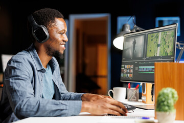 Fototapeta premium Content creator adjusting montage clips with color grading on motion graphics interface at home, adding visual effects on videography software. Video maker editing movie segments.