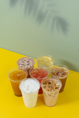 Takeaway glasses of summer drinks with ice. Colourful lemonades and coctails angle view
