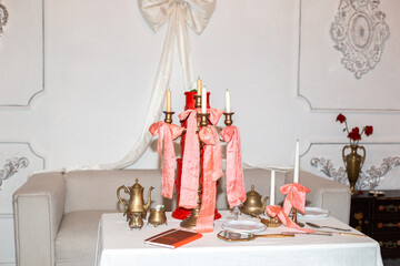A candlestick with pink bows stands on the table