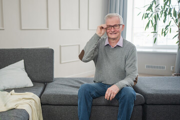 Portrait of confident stylish European middle aged senior man at home. Older mature 70s man...