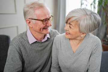Senior adult mature couple hugging at home. Mid age old husband and wife embracing with tenderness love enjoying sweet bonding wellbeing. Grandmother grandfather together. Family moment love and care