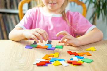 little 5 year old girl playing at home with wooden blocks, child's hand explore intricate world...