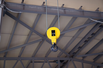 Overhead traveling cathead with steel hooks in industrial industrial warehouse. Steel slings.
