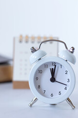 Alarm clock with calendar and holy bible book on white. Close-up. Christian biblical concept of time running, patience, progress, Scripture study, and prayer.