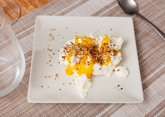 Homemade hearty breakfast - cottage cheese with honey sauce. dish is richly decorated with sesame...