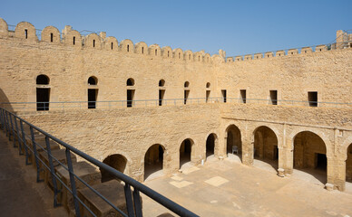 Sunlit inner courtyard of ancient Ribat of Sousse, traditionally flanked by with sturdy stone walls...