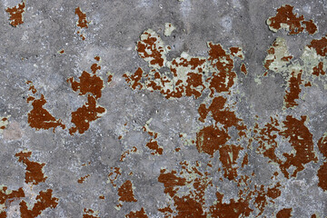 Brown peeling paint on the wall. Old concrete wall with cracked flaking paint. Weathered rough...