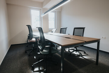 Contemporary office space featuring a stylish wooden conference table, ergonomic chairs, and a...