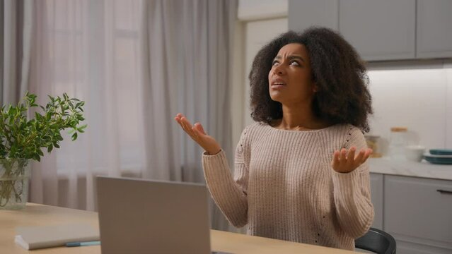 Annoyed angry woman African American businesswoman freelancer online working laptop at home kitchen stressed displeased mad female girl scream crazy with noise sound close ears disturb noisy at house