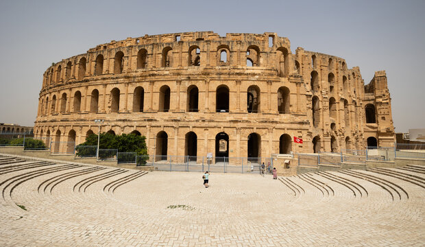 Scenic view of well-preserved grand El Jem Amphitheatre in Tunisia, showcasing magnificence of Roman architecture, towering against clear blue sky