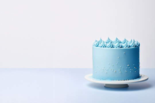 Blue cake with sprinkles on a solid light blue background with copy space, boy birthday, gender reveal or baby shower