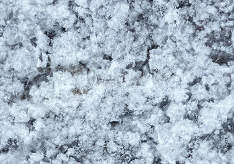 Crystals of sea salt on black volcanic lava stone of the coast of Atlantic ocean.Natural background. Tenerife,Canary Islands,Spain. Selective focus.