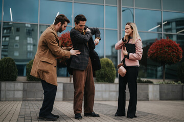 Three business professionals engaging in a discussion outside a modern office building.
