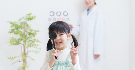 眼科で視力検査する子供