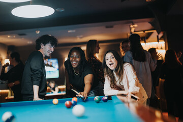 Group of friends having a delightful time at a bar, playing pool and sharing happy, joyful moments together during a night out.