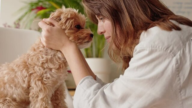 Intimate moment between a woman and her dog as they touch foreheads, showcasing the special bond and affection shared.