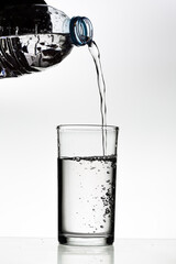 Pouring water into a glass on a white background