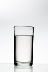Pouring water into a glass on a white background