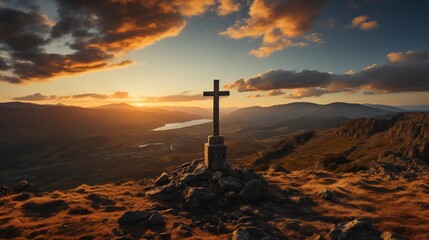 A solitary cross atop a mountain overlooks a stunning sunset vista