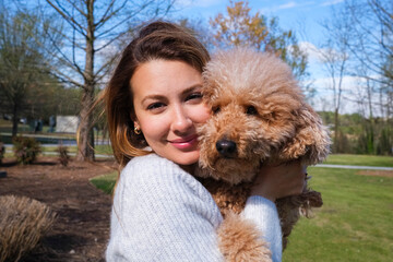 Young woman with cute doodle dog