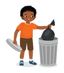 Cute little African boy taking out the trash in garbage bag into recycling bin