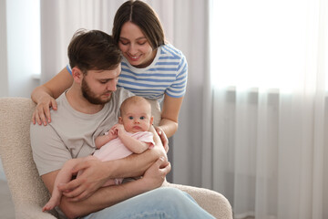 Happy family. Parents with their cute baby at home, space for text