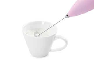 Whisking milk in cup with mini mixer (frother wand) isolated on white