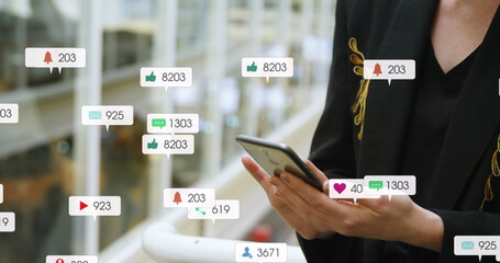 Image of message icons with changing numbers over midsection of caucasian woman using cellphone