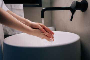 Closeup side view of unrecognizable woman washing dirty hands rubbing using sanitizer soap, rinsing...