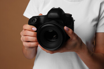 Photographer with camera on brown background, closeup