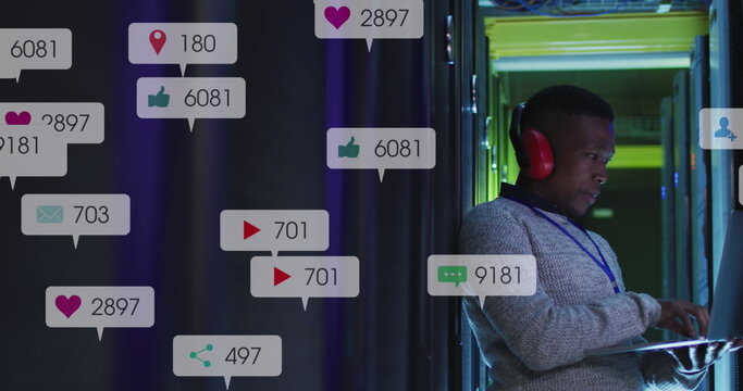 Image of icons and numbers over african american male it technician by computer servers - Powered by Adobe